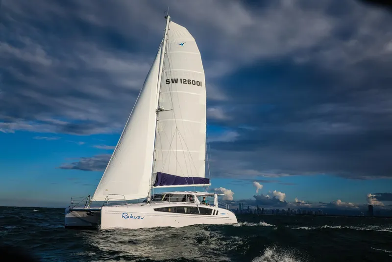 Slide: The Image of 2025 Seawind 1260 catamaran sailing on open water under a cloudy sky. - 5