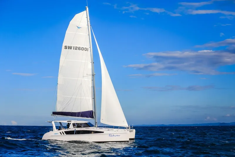 Slide: The Image of 2025 Seawind 1260 catamaran sailing on open ocean under clear blue sky. - 6