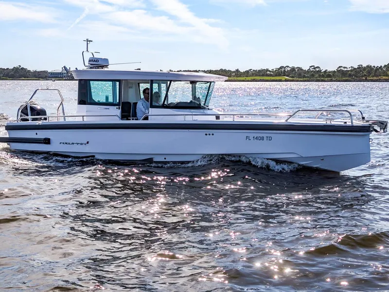 The Image of 2022 Axopar 28 CABIN boat cruising on a sunny day, side view. - 0