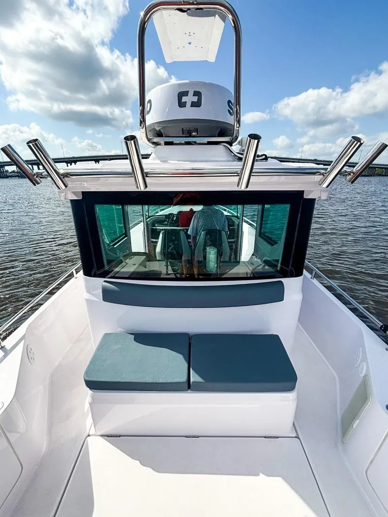 Slide: The Image of 2022 Axopar 28 CABIN boat with seating, on calm water under a blue sky. - 13