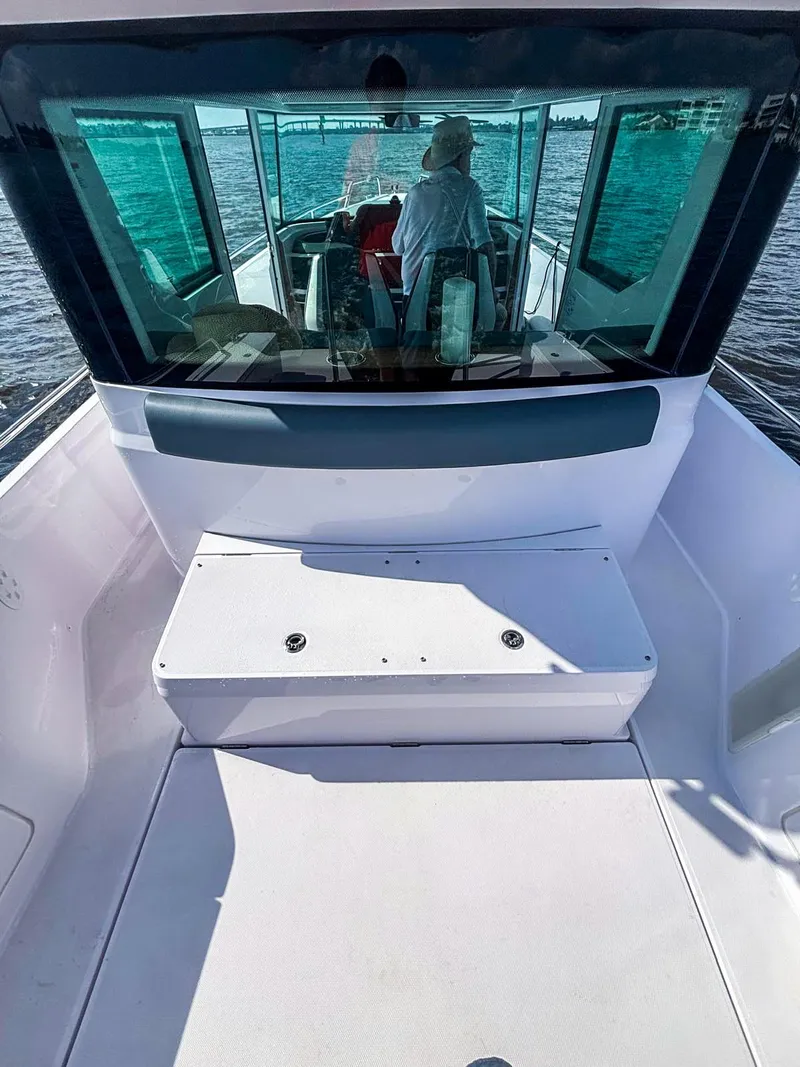 Slide: The Image of 2022 Axopar 28 CABIN boat interior with seating, navigating on water. - 14
