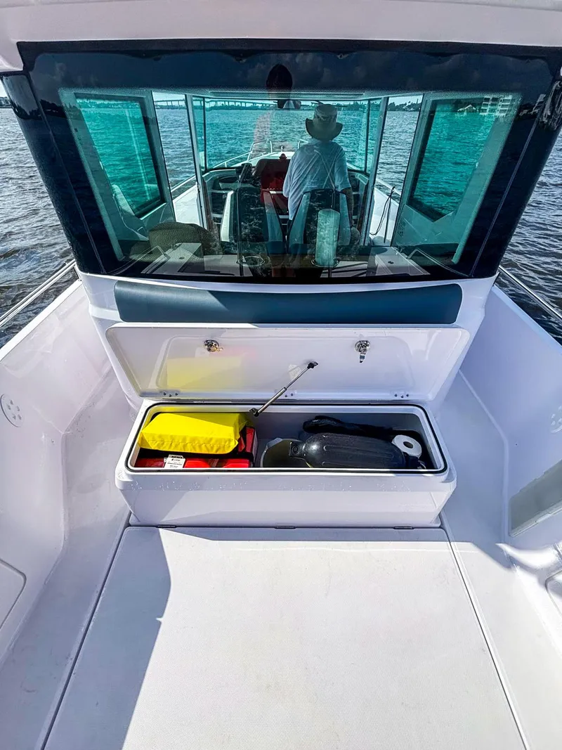 Slide: The Image of 2022 Axopar 28 CABIN boat with open storage compartment on deck. - 15
