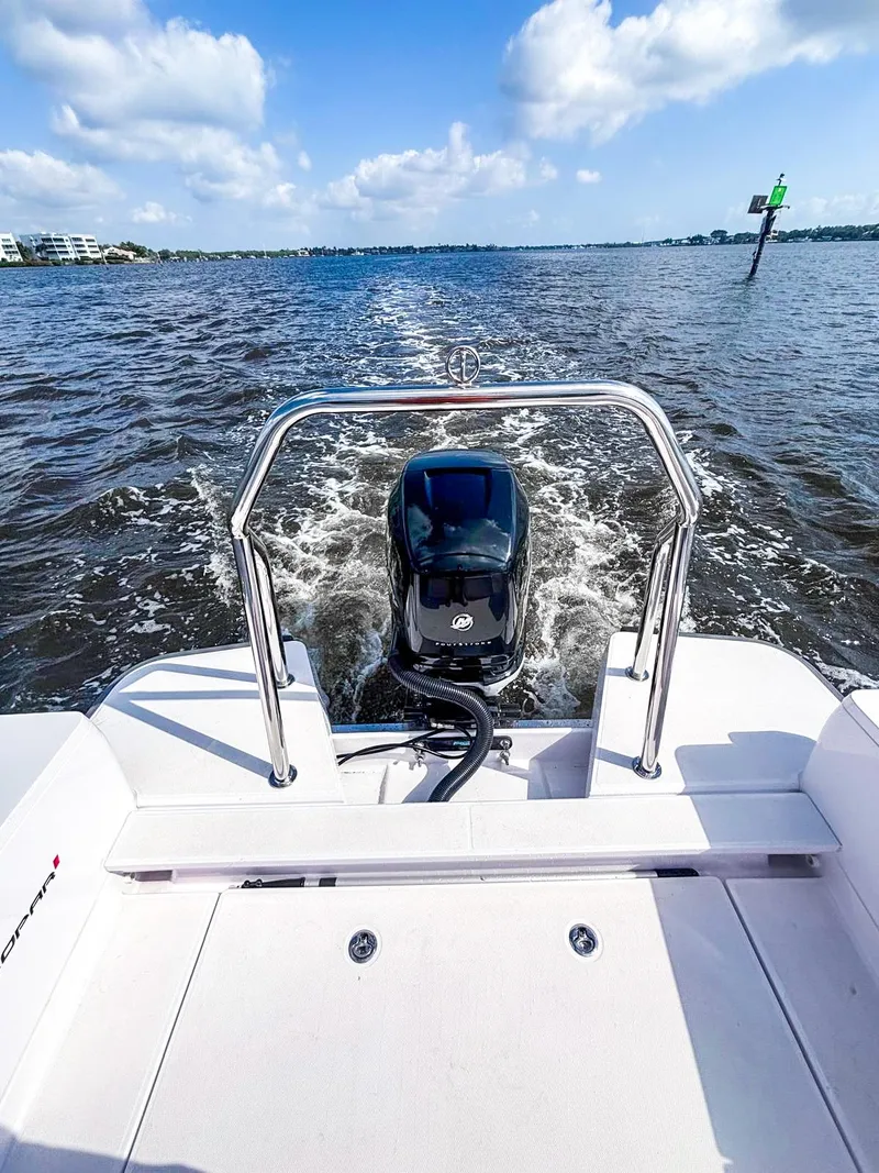 Slide: The Image of 2022 Axopar 28 CABIN boat cruising on open water under a clear blue sky. - 16