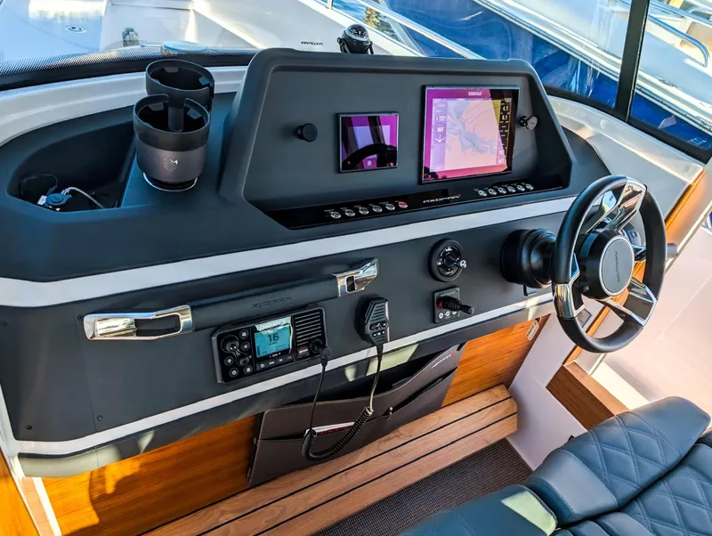 Slide: The Image of 2022 Axopar 28 CABIN helm with modern navigation equipment and steering wheel. - 3