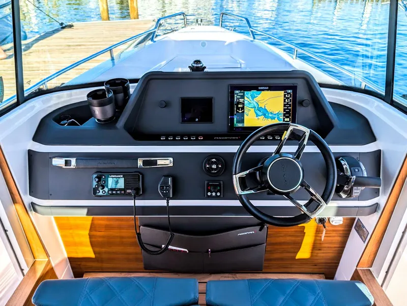 Slide: The Image of 2022 Axopar 28 CABIN helm with navigation system and steering wheel, docked by the water. - 4