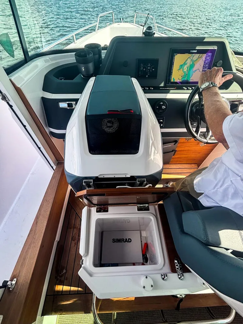 Slide: The Image of 2022 Axopar 28 CABIN interior with navigation system and Simrad equipment on open water. - 5