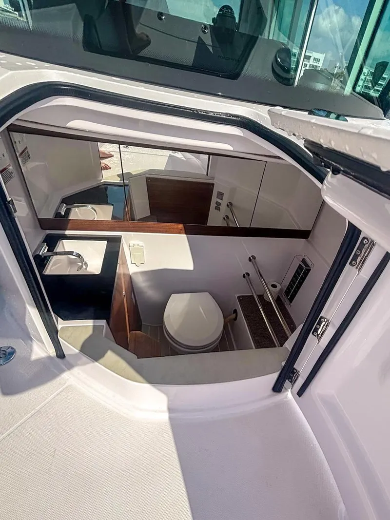Slide: The Image of 2022 Axopar 28 CABIN interior with compact bathroom and modern amenities. - 7