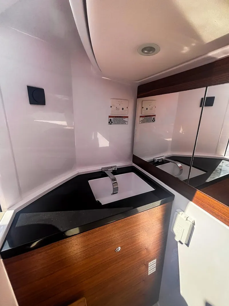 Slide: The Image of 2022 Axopar 28 CABIN bathroom with modern sink and mirrored cabinet. - 8