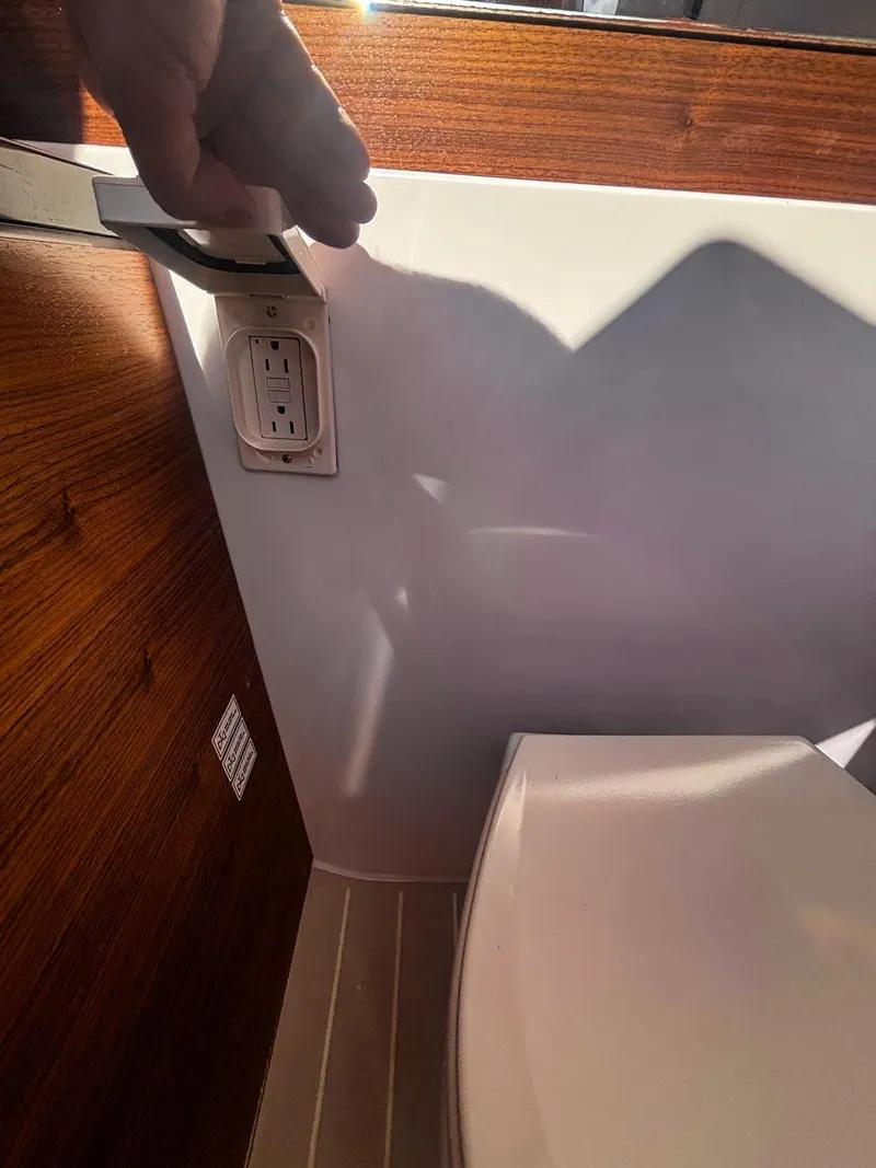 Slide: The Image of 2022 Axopar 28 CABIN interior with wood paneling and electrical outlet. - 9