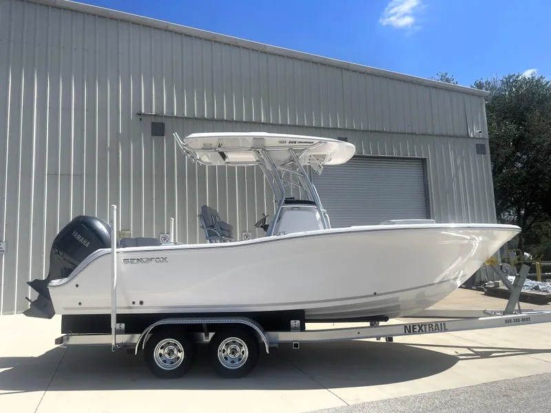 Slide: The Image of 2023 Sea Fox 228 Commander boat on trailer, parked outside a warehouse. - 2