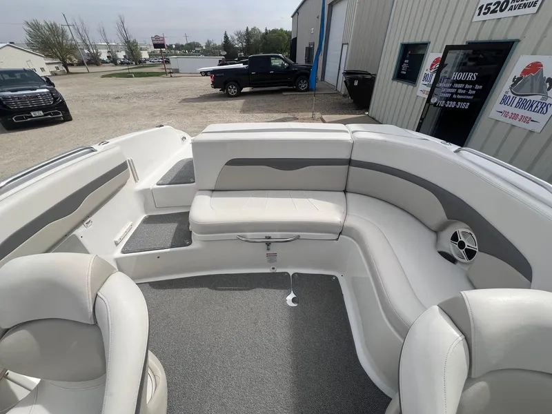 Slide: The Image of 2008 Chaparral 220 SSi boat interior with white and gray seating, parked outside a building. - 20