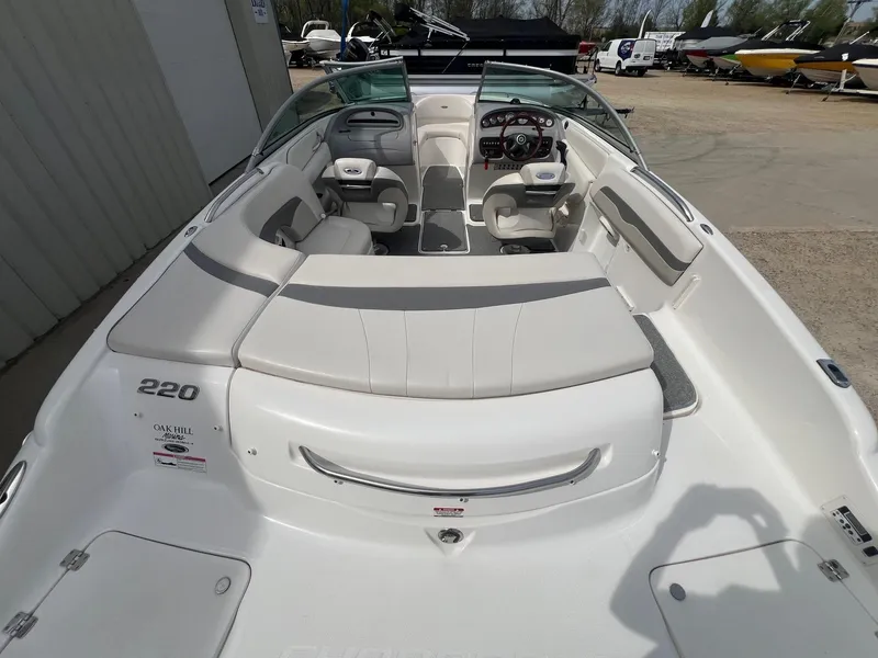 Slide: The Image of 2008 Chaparral 220 SSi boat interior with seating and steering wheel, parked outdoors. - 8