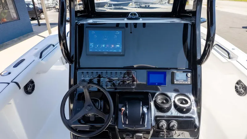 Slide: The Image of 2025 Tidewater 272cc boat dashboard with steering wheel and electronic displays. - 11