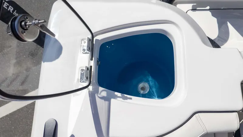 Slide: The Image of Livewell on 2025 Tidewater 272cc boat, featuring a blue interior and open lid. - 14