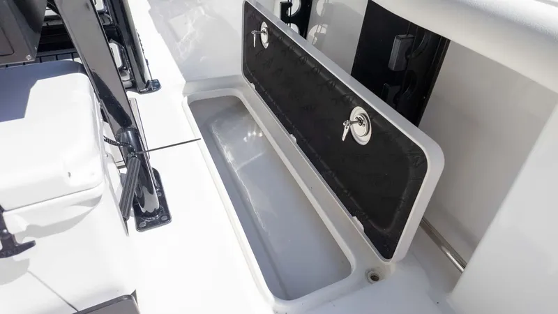Slide: The Image of 2025 Tidewater 272cc boat storage compartment with open hatch and key lock. - 17