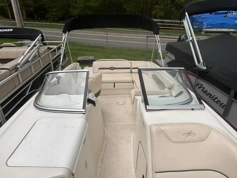 Slide: The Image of 2000 Monterey 220 Explorer boat with open seating and windshield, docked alongside other boats. - 3