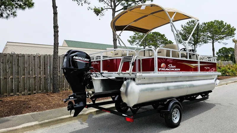Slide: The Image of 2025 Sun Tracker Bass Buggy 18 DLX pontoon boat with Mercury engine on trailer. - 2