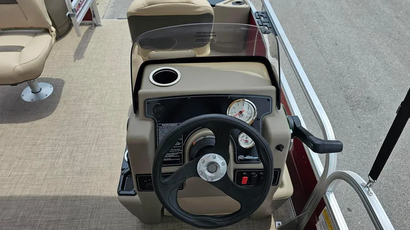 Slide: The Image of 2025 Sun Tracker Bass Buggy 18 DLX steering console with beige seating and dashboard. - 8