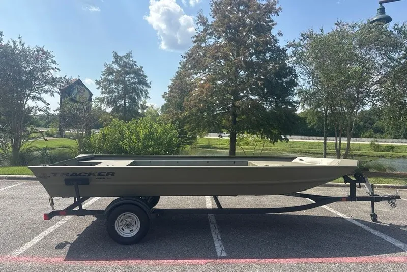 The Image of 2025 Tracker Grizzly 1860 Utility boat on trailer in sunny parking lot. - 0