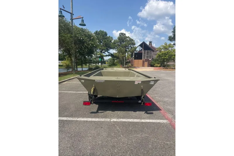 Slide: The Image of 2025 Tracker Grizzly 1860 Utility boat on trailer in parking lot, sunny day. - 12