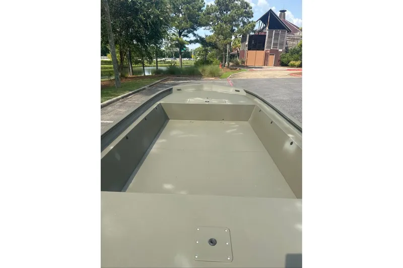 Slide: The Image of 2025 Tracker Grizzly 1860 Utility boat, empty interior view, parked outdoors. - 9