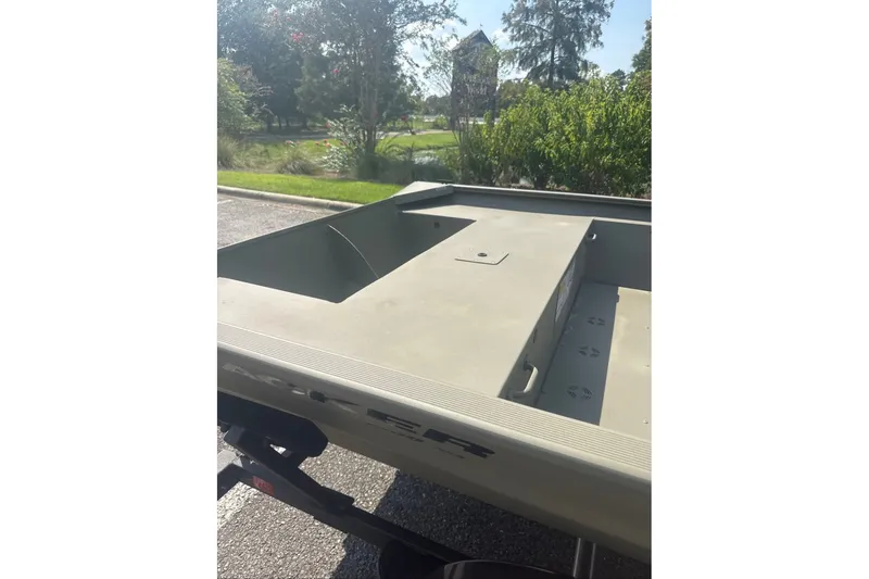 Slide: The Image of 2025 Tracker Grizzly 1860 Utility boat on a sunny day, parked outdoors. - 8