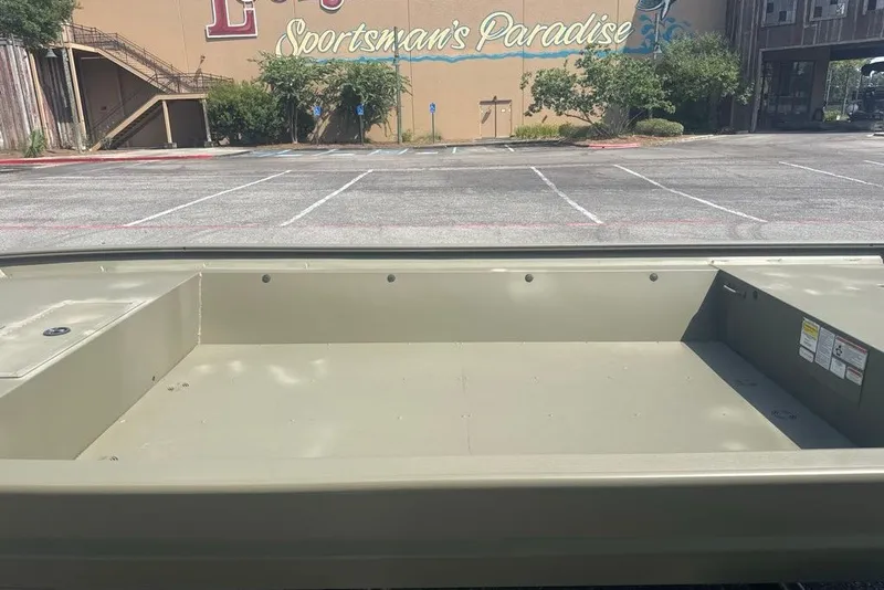 Slide: The Image of 2025 Tracker Grizzly 1860 Utility boat in empty parking lot, showcasing spacious interior. - 3