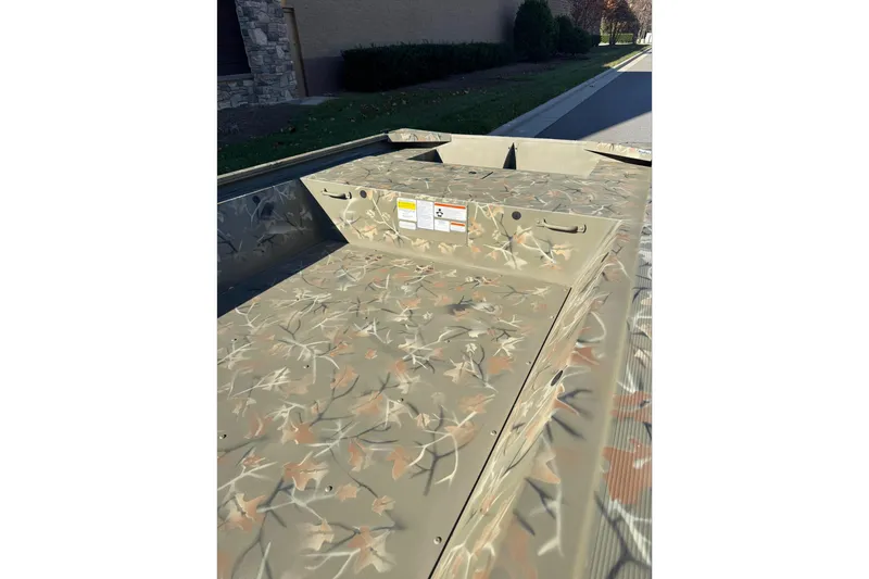 Slide: The Image of 2025 Tracker Grizzly 1648 Jon boat with camouflage pattern on a sunny day. - 5