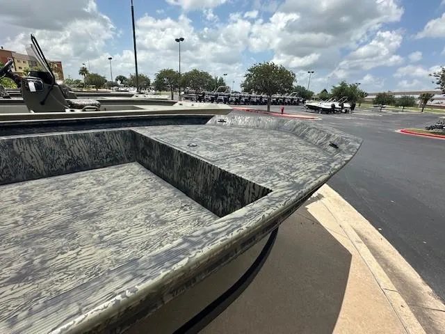 Slide: The Image of 2025 Tracker GRIZZLY 1860 Utility boat in parking lot under cloudy sky. - 2