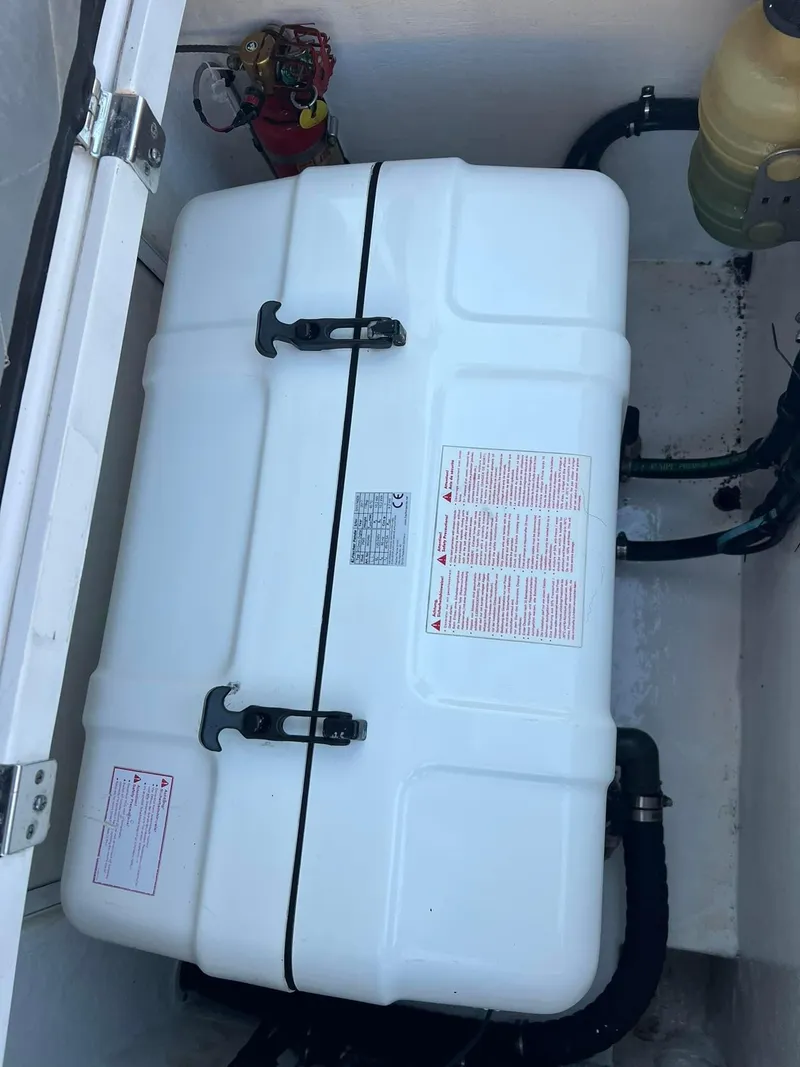 Slide: The Image of 2019 Intrepid 475 Sport Yacht engine compartment with white storage container. - 10