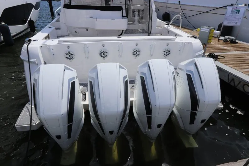 Slide: The Image of 2019 Intrepid 475 Sport Yacht with four powerful outboard engines docked at a marina. - 18