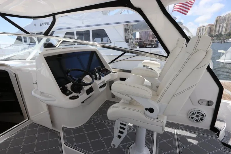 Slide: The Image of 2019 Intrepid 475 Sport Yacht helm with luxurious seating and modern controls. - 35
