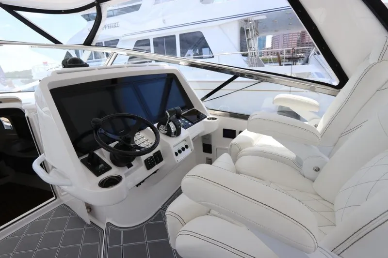 Slide: The Image of 2019 Intrepid 475 Sport Yacht cockpit with luxurious white seating and modern controls. - 37