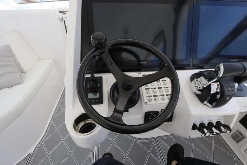 Slide: The Image of 2019 Intrepid 475 Sport Yacht helm with steering wheel and control panel. - 39