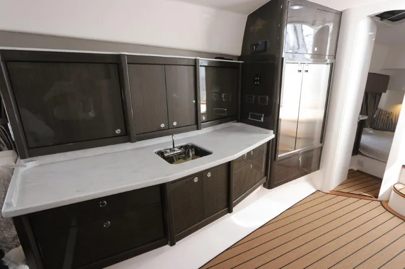 Slide: The Image of 2019 Intrepid 475 Sport Yacht interior kitchen with sleek cabinetry and modern appliances. - 45