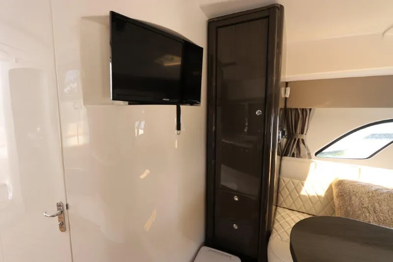 Slide: The Image of Interior of 2019 Intrepid 475 Sport Yacht with TV, cabinet, and seating area. - 48