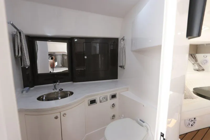 Slide: The Image of 2019 Intrepid 475 Sport Yacht bathroom with sink, mirror, and toilet. - 49