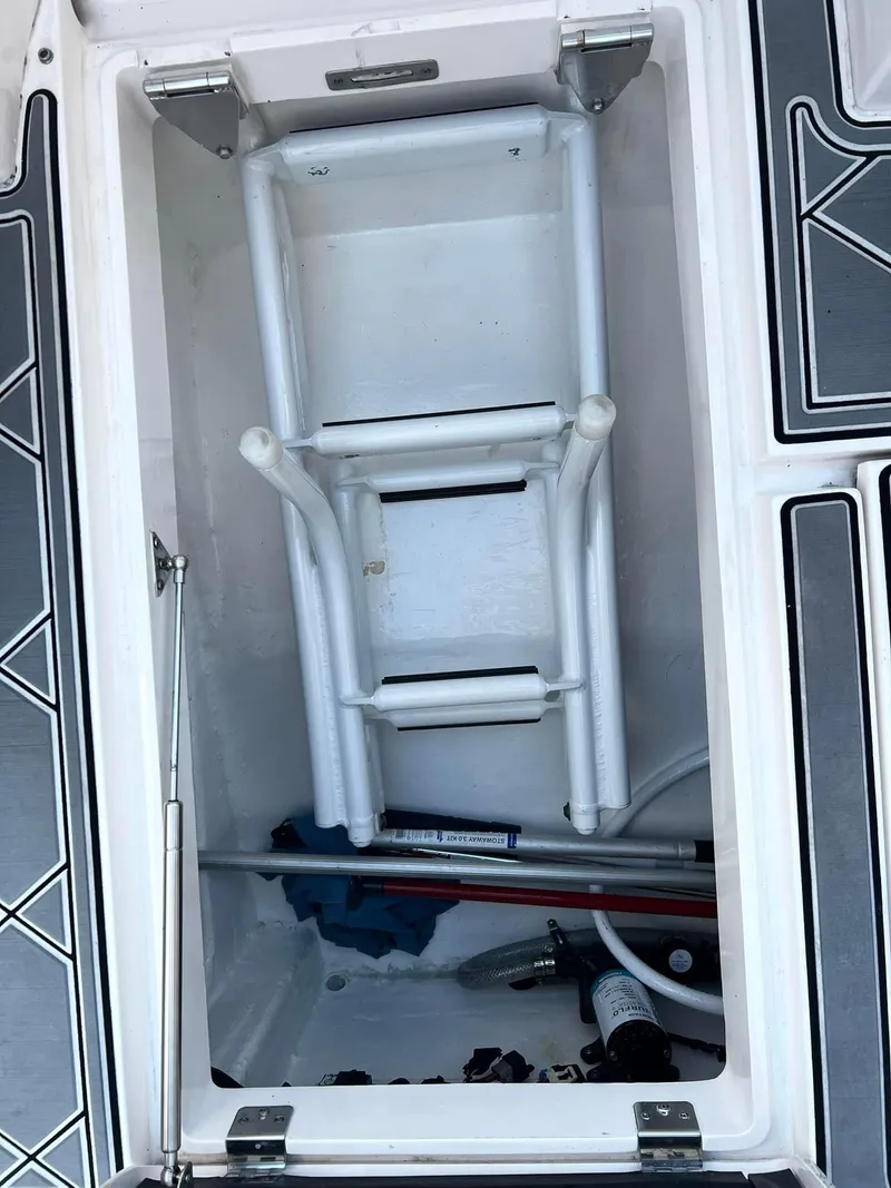 Slide: The Image of 2019 Intrepid 475 Sport Yacht storage compartment with folded ladder and equipment. - 8