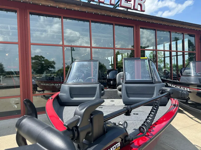 Slide: The Image of 2025 Tracker Pro Guide V-16 WT boat displayed outside a showroom. - 2