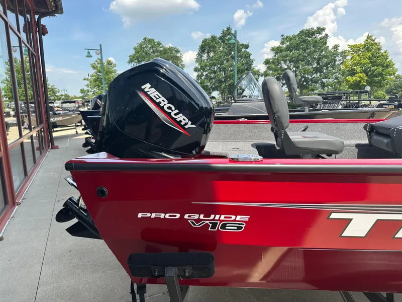 Slide: The Image of 2025 Tracker Pro Guide V-16 WT boat with Mercury engine, parked outdoors. - 3