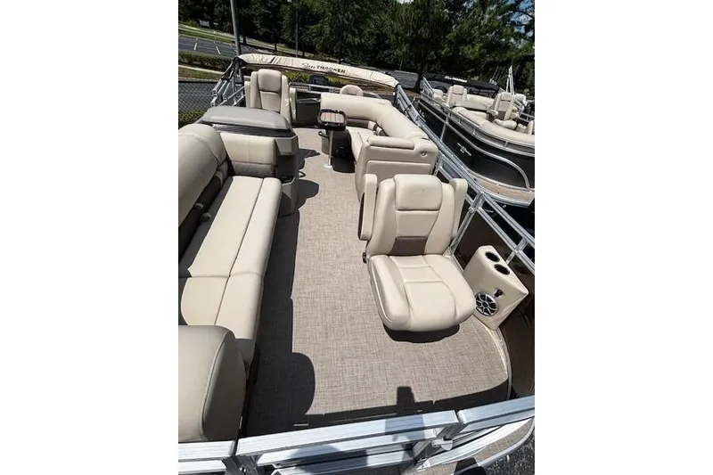 Slide: The Image of 2025 Sun Tracker SportFish 20 DLX pontoon boat interior with beige seating and spacious layout. - 4