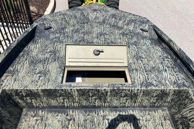 Slide: The Image of 2025 Tracker Grizzly 1860 Utility boat with camo pattern and storage compartment. - 3
