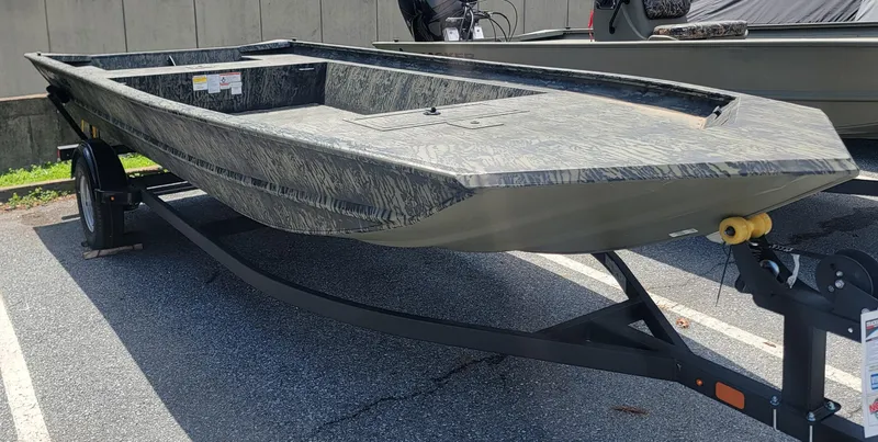 Slide: The Image of 2025 Tracker GRIZZLY 1860 Utility boat on trailer, parked outdoors. - 2