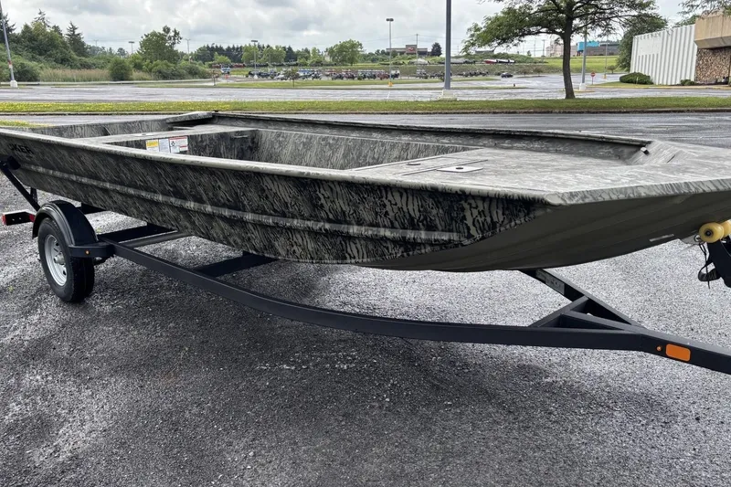 The Image of 2025 Tracker Grizzly 1860 Utility boat on trailer, parked outdoors on a cloudy day. - 0