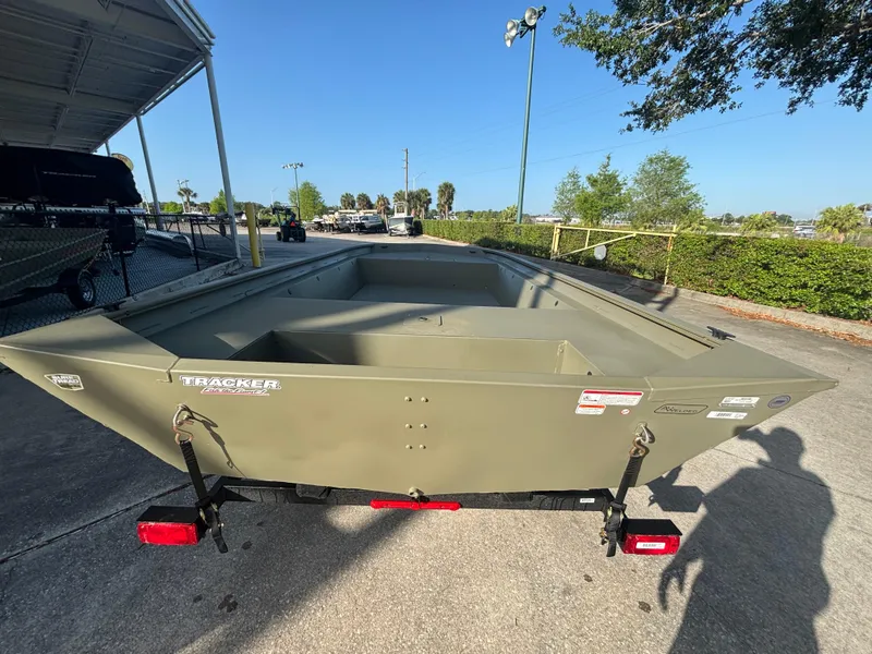 Slide: The Image of 2025 Tracker GRIZZLY 1860 Utility boat on trailer, parked outdoors. - 2