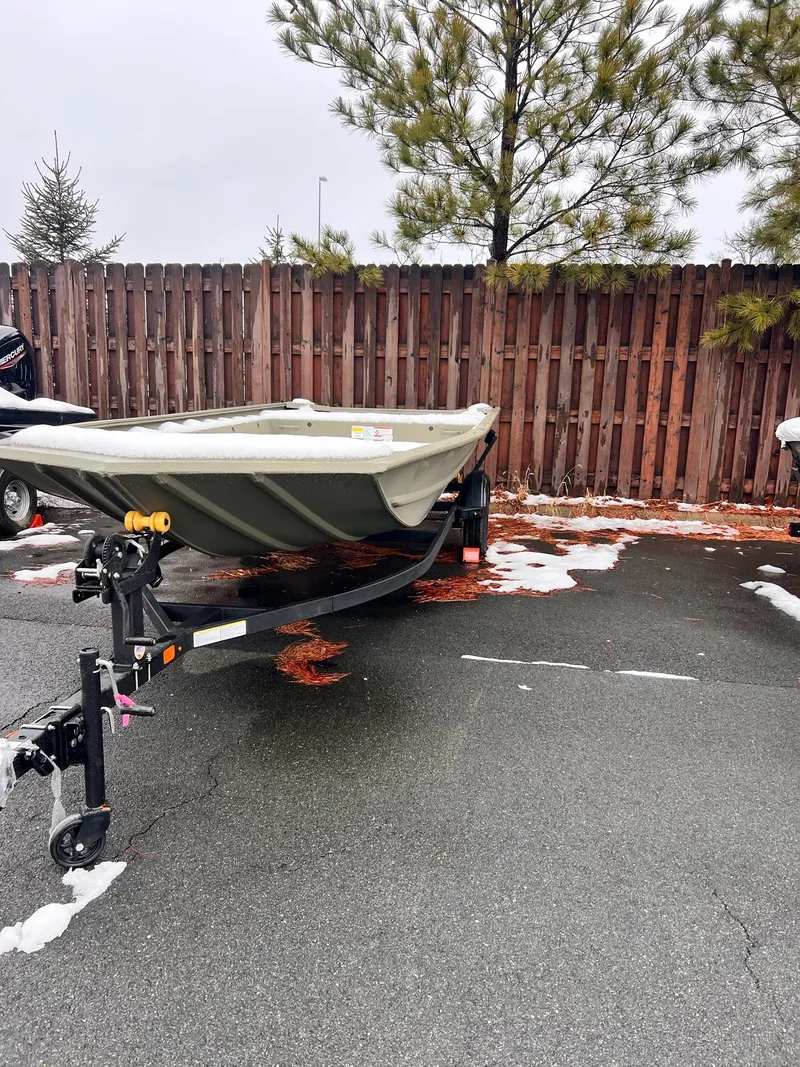 The Image of 2025 Tracker GRIZZLY 1860 Utility boat on trailer, parked on snowy pavement. - 0