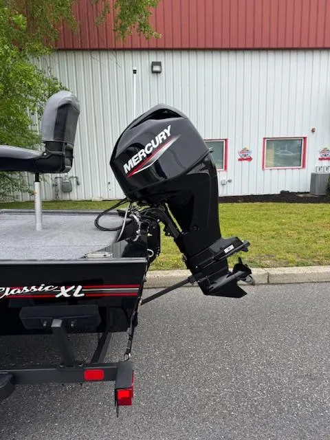 Slide: The Image of 2025 Tracker Bass Tracker Classic XL with Mercury outboard motor, parked outdoors. - 7