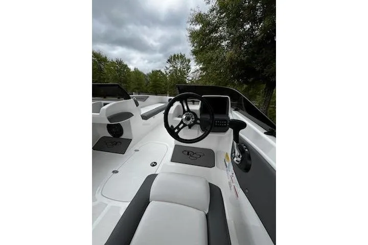 Slide: The Image of 2025 Tahoe T21 boat interior with steering wheel, dashboard, and seating under cloudy sky. - 3