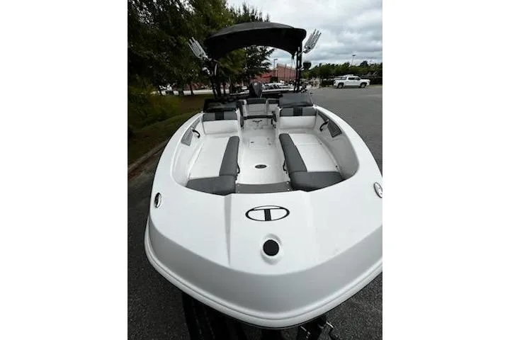 Slide: The Image of 2025 Tahoe T21 boat with sleek design and spacious seating, parked outdoors. - 4