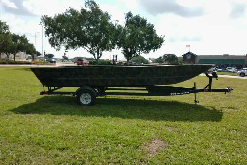 Slide: The Image of 2025 Tracker Grizzly 1860 Utility boat on trailer, parked on grassy area. - 25